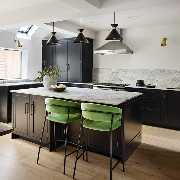 Nhà bếp với tủ tối màu, bề mặt đá cẩm thạch và ghế quầy bar màu xanh lá cây