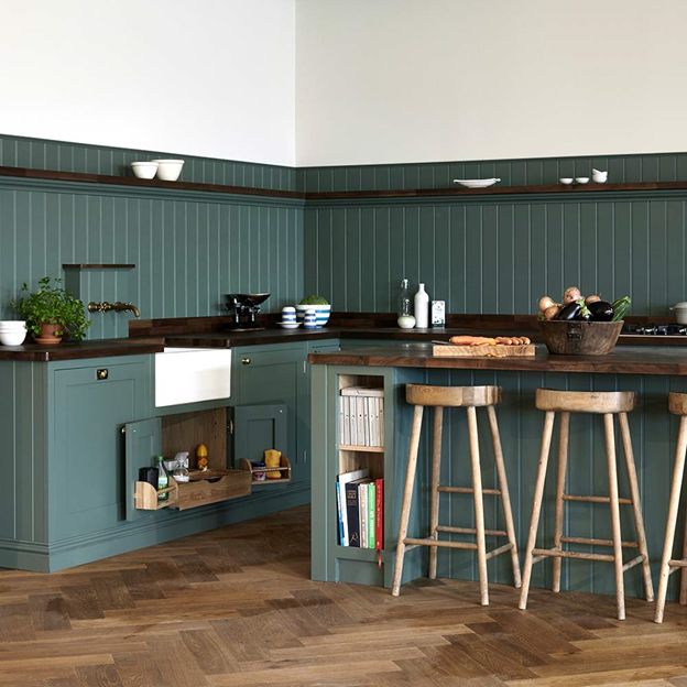 Nhà bếp màu xanh lá cây với vách ngăn và đảo với ghế quầy bar bằng gỗ